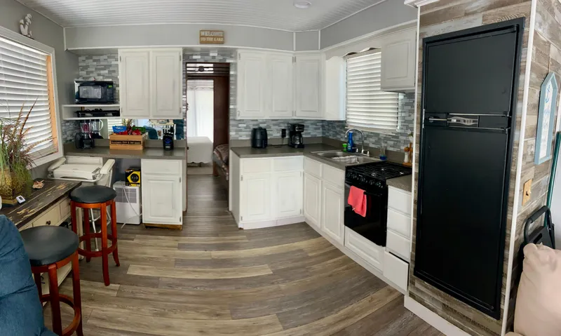 Slide: The Image of 1987 Jamestowner houseboat kitchen with white cabinets, modern appliances, and wood flooring. - 8