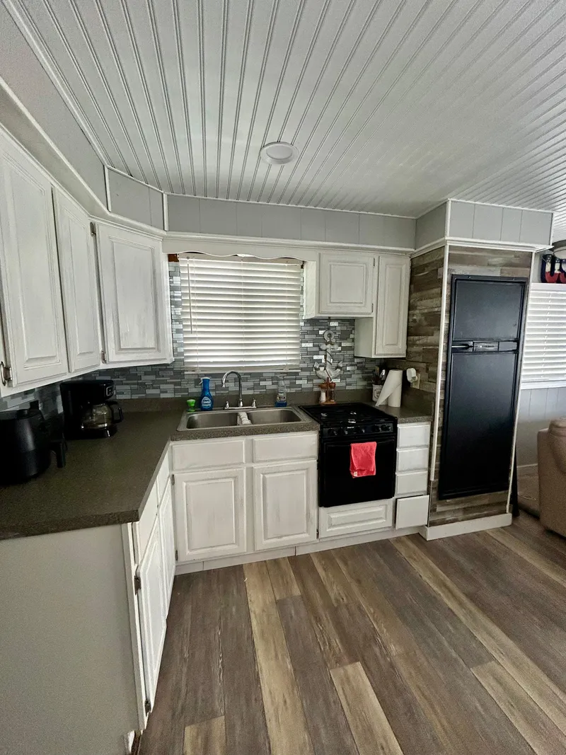 Slide: The Image of 1987 Jamestowner houseboat kitchen with modern appliances, white cabinets, and wood flooring. - 9