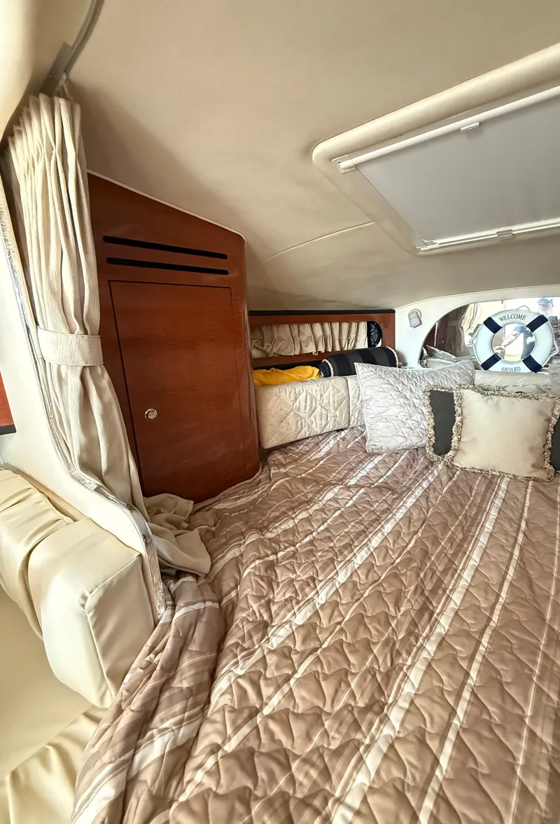 Slide: The Image of Interior cabin of 2004 Sea Ray 280 Sundancer with cozy bedding and wooden cabinetry. - 10
