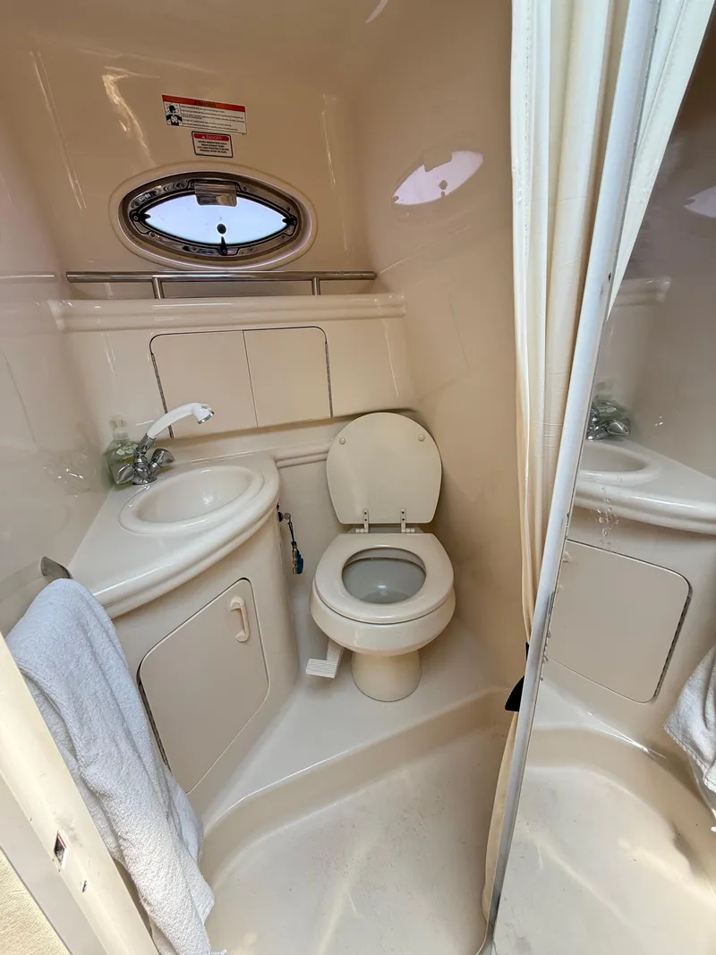 Slide: The Image of Compact bathroom in 2004 Sea Ray 280 Sundancer boat with sink and toilet. - 13