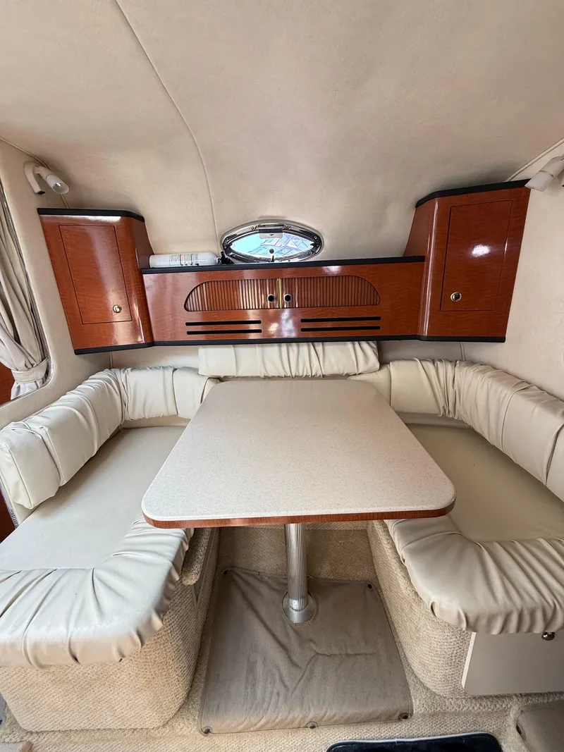 Slide: The Image of Interior of 2004 Sea Ray 280 Sundancer with cushioned seating and wooden cabinetry. - 7