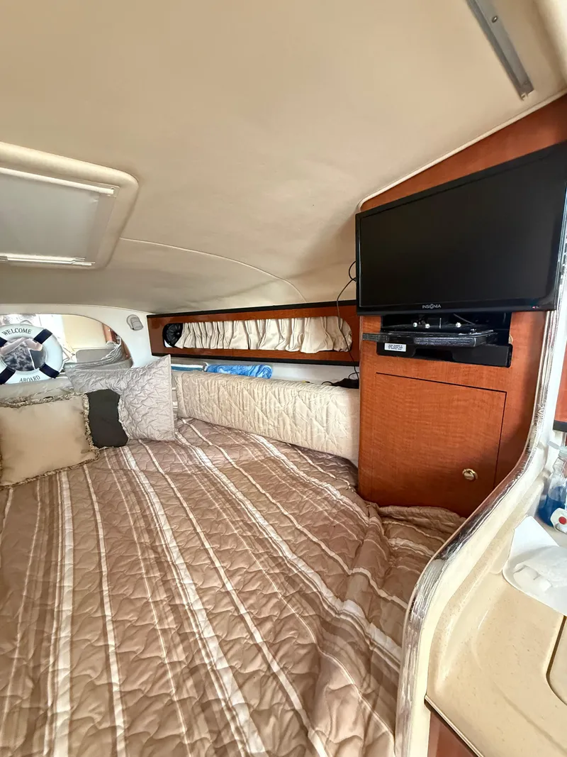 Slide: The Image of Interior cabin of 2004 Sea Ray 280 Sundancer with bed and mounted TV. - 8