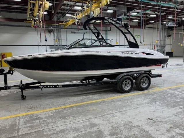 Slide: The Image of 2024 Tahoe 210 S boat on trailer in industrial setting. - 0