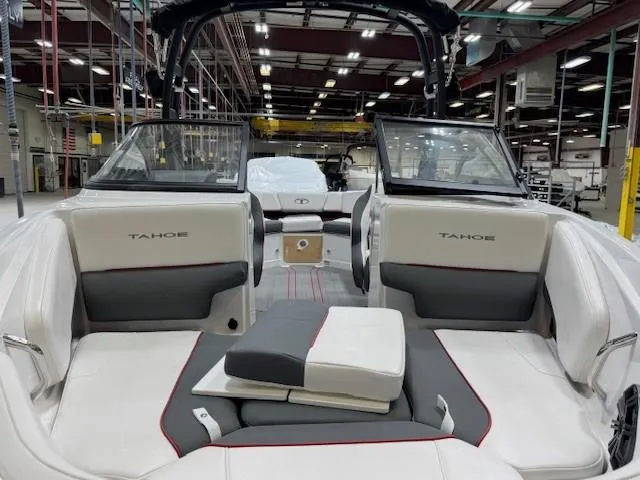 Slide: The Image of 2024 Tahoe 210 S boat interior with seating and windshield in a warehouse setting. - 2