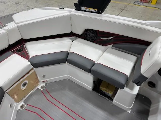 Slide: The Image of 2024 Tahoe 210 S boat interior with white and gray seating, red accents, and speaker. - 8
