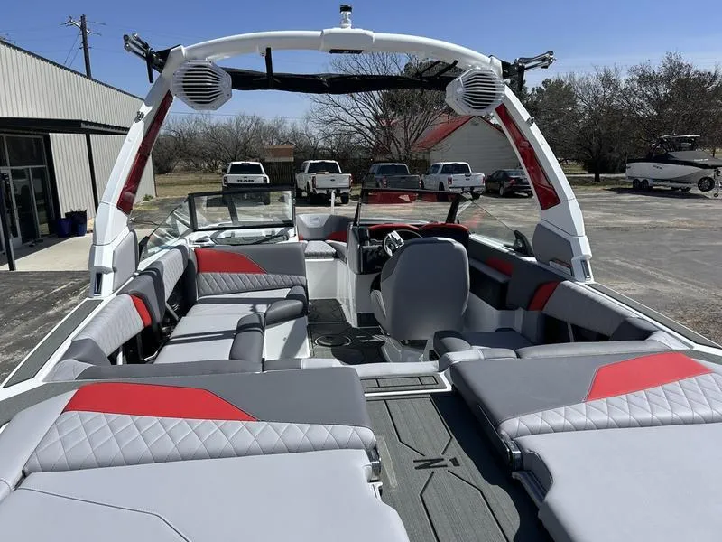 Slide: The Image of 2025 Tigé Z1 boat interior with gray and red seating, parked outdoors. - 4