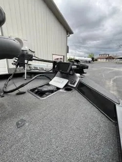 Slide: The Image of 2020 Ranger RT198P boat deck with navigation equipment, parked near a building under cloudy skies. - 4