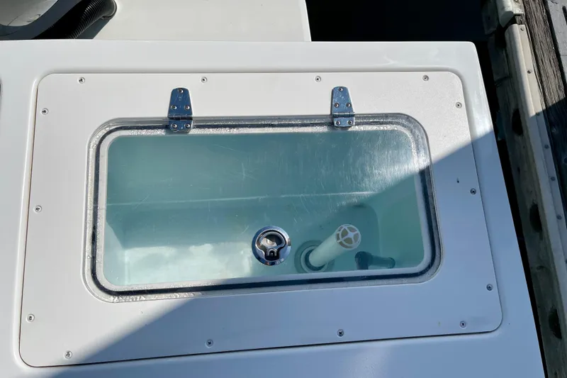 Slide: The Image of Livewell on 2016 Parker 2501 Center Console boat, featuring a clear lid and secure hinges. - 11