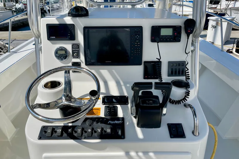 Slide: The Image of 2016 Parker 2501 Center Console boat dashboard with steering wheel and navigation equipment. - 20