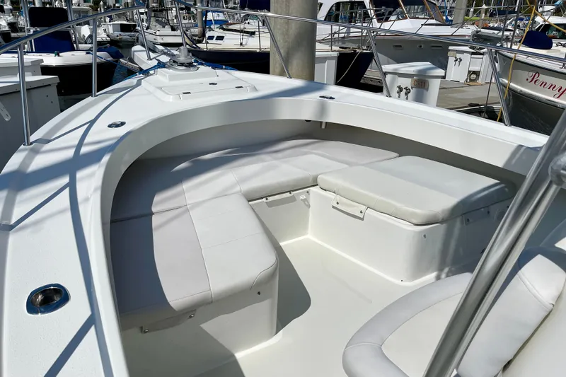 Slide: The Image of 2016 Parker 2501 Center Console boat with white seating, docked at a marina. - 25