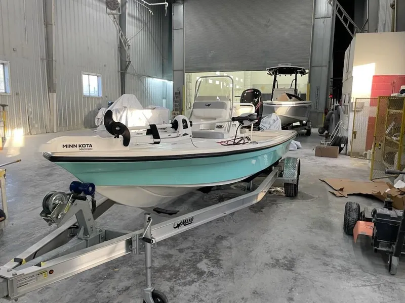 Slide: The Image of 2024 Mako 18 LTS boat in a garage, on a trailer, with Minn Kota motor. - 3