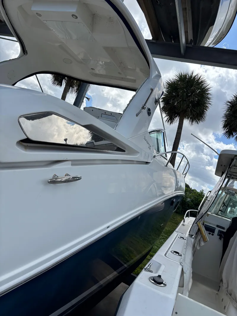 Slide: The Image of 2010 Sea Ray 38 boat docked under a canopy with palm trees in the background. - 3