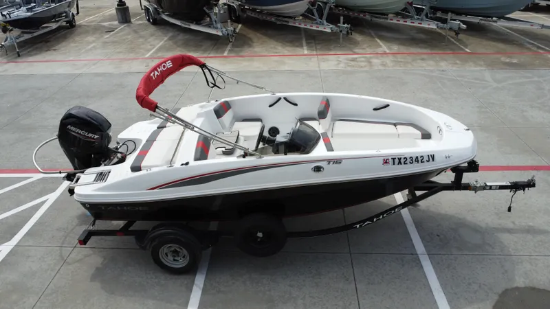 Slide: The Image of 2021 TAHOE TAHT16 boat on trailer with Mercury outboard motor, parked in a lot. - 12