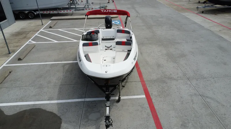 Slide: The Image of 2021 TAHOE TAHT16 boat parked in a marina lot, featuring red and white design. - 14
