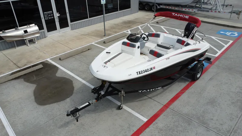 Slide: The Image of 2021 TAHOE TAHT16 boat on trailer in parking lot, red canopy, white and black design. - 15