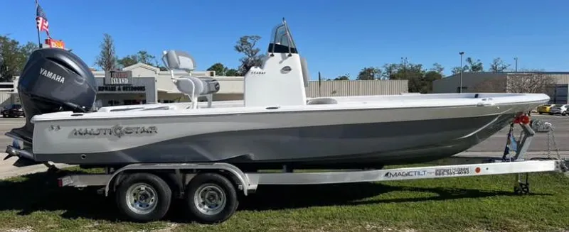 Slide: The Image of 2025 NauticStar 224 Bay boat on trailer, side view, outdoors. - 1