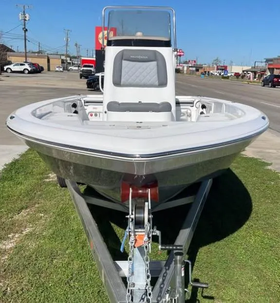 Slide: The Image of 2025 NauticStar 224 Bay boat on trailer, parked outdoors, front view. - 2