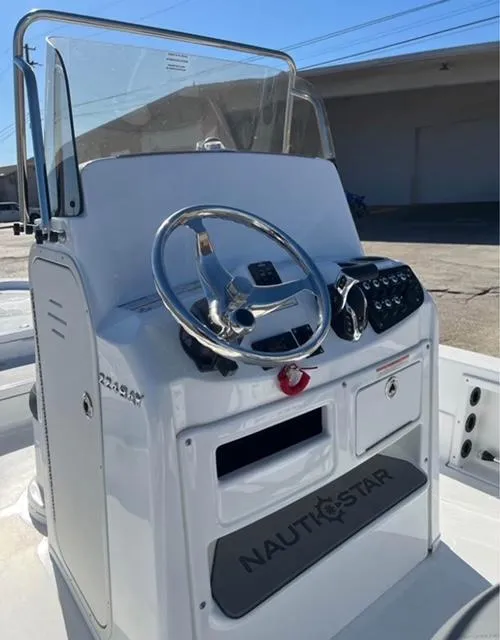 Slide: The Image of 2025 NauticStar 224 Bay boat console with steering wheel and controls. - 7