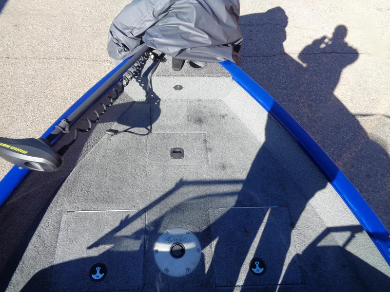 Slide: The Image of 2018 Tracker Pro Guide V-16 WT boat interior with blue trim and fishing equipment. - 11