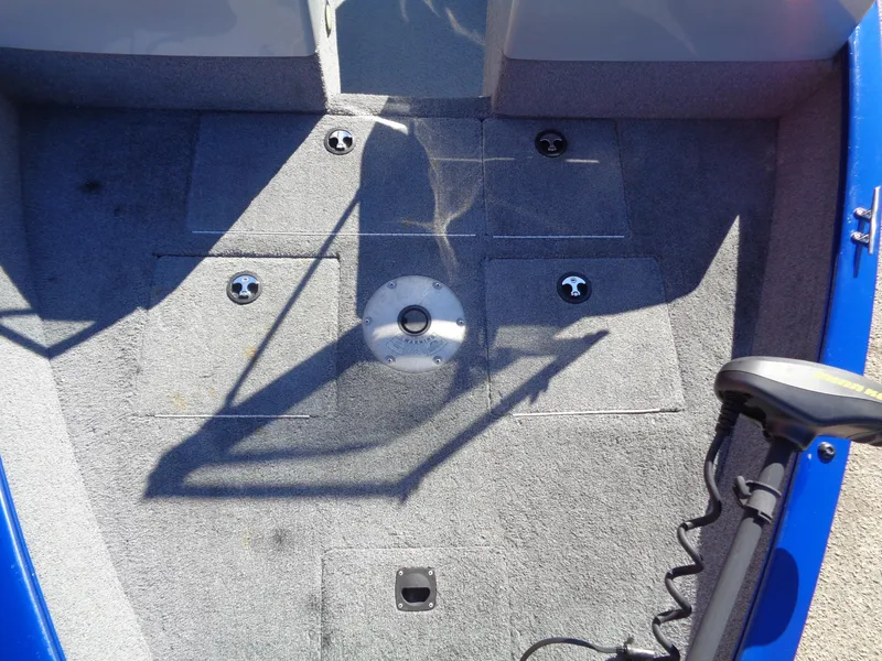 Slide: The Image of 2018 Tracker Pro Guide V-16 WT boat interior with carpeted floor and fishing rod holder. - 12