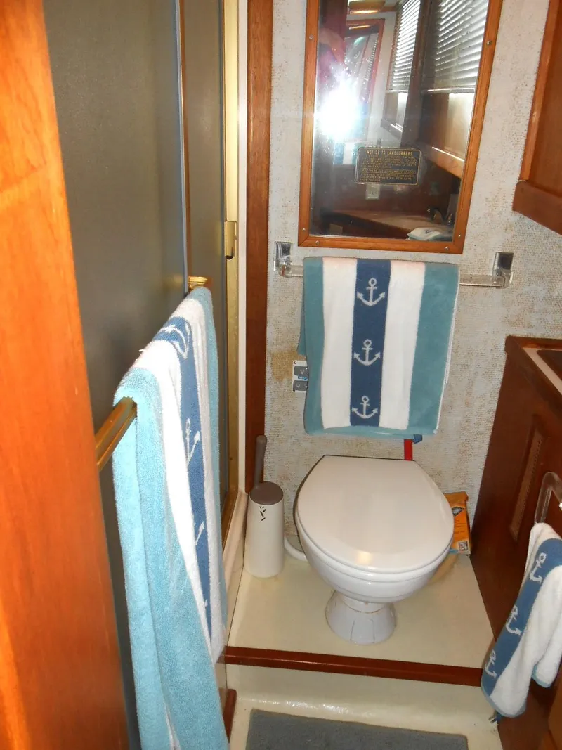 Slide: The Image of 1983 Californian 42 yacht bathroom with nautical-themed towels and compact design. - 13