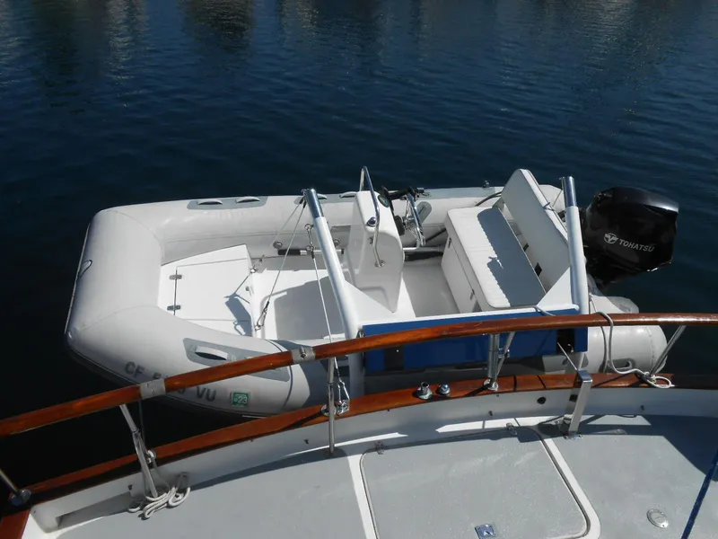 Slide: The Image of 1983 Californian 42 yacht with inflatable dinghy on calm water. - 17