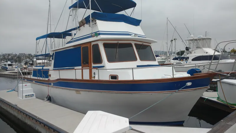 Slide: The Image of 1983 Californian 42 yacht docked at marina, featuring blue and white design. - 18