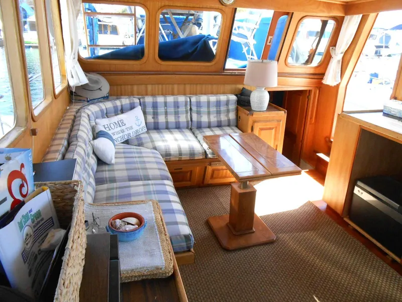 Slide: The Image of Cozy interior of 1983 Californian 42 yacht with plaid seating and wooden furnishings. - 2