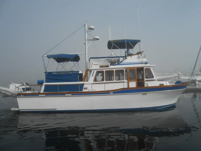 Slide: The Image of 1983 Californian 42 yacht on calm water, featuring blue and white design. - 20