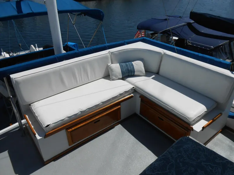 Slide: The Image of White cushioned seating on 1983 Californian 42 yacht deck, with wooden storage underneath. - 3