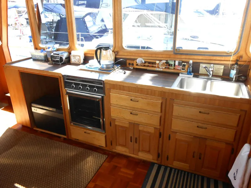 Slide: The Image of 1983 Californian 42 yacht kitchen with wooden cabinets, stove, and sink. - 4