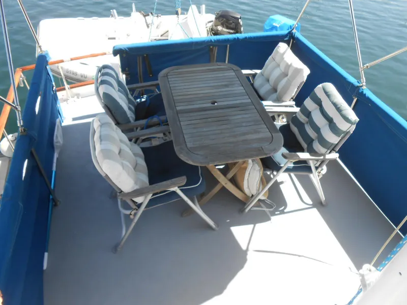 Slide: The Image of Outdoor seating area on a 1983 Californian 42 boat with cushioned chairs and table. - 7