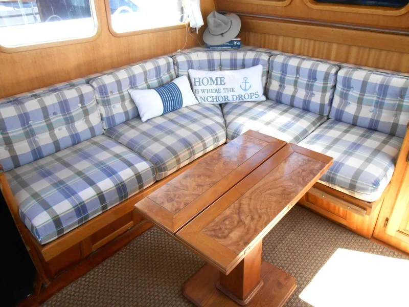 Slide: The Image of Cozy seating area on 1983 Californian 42 yacht with plaid cushions and wooden table. - 9
