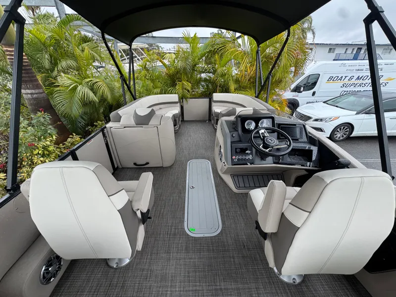 Slide: The Image of 2025 Avalon Catalina Quad Lounge boat interior with seating and steering console. - 16
