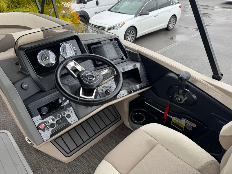 Slide: The Image of 2025 Avalon Catalina Quad Lounge boat dashboard with steering wheel and controls. - 18
