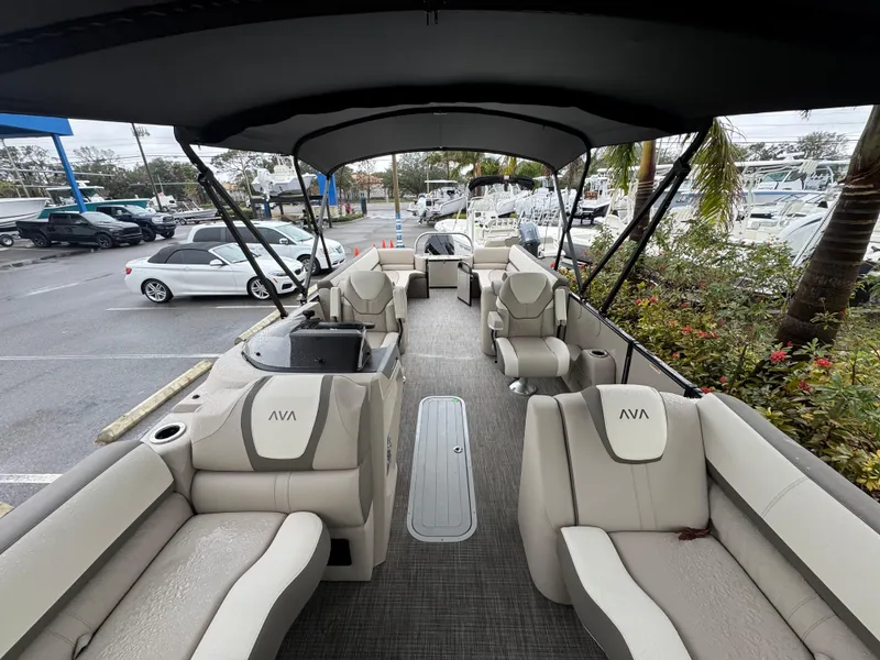 Slide: The Image of 2025 Avalon Catalina Quad Lounge boat with spacious seating and canopy, parked in a marina. - 29
