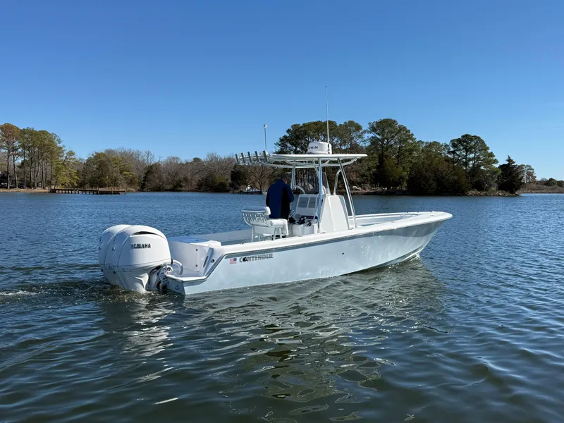 The Image of 2025 Contender 25T boat cruising on a calm lake with Yamaha engine. - 0