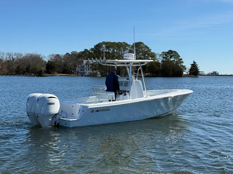 Slide: The Image of 2025 Contender 25T boat with dual Yamaha engines on a calm lake. - 2