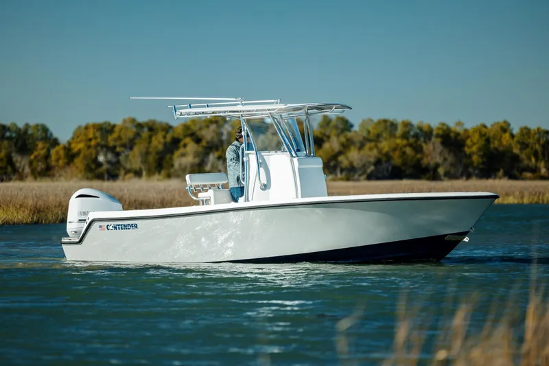 Slide: The Image of 2025 Contender 25T boat cruising on a calm river with scenic background. - 4