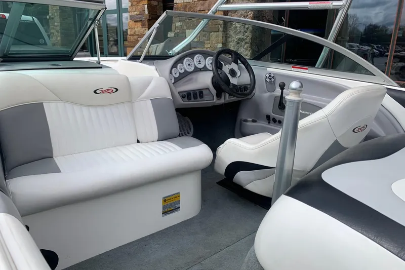 Slide: The Image of Interior of a 2000 MasterCraft X5 boat with white and gray seating. - 1