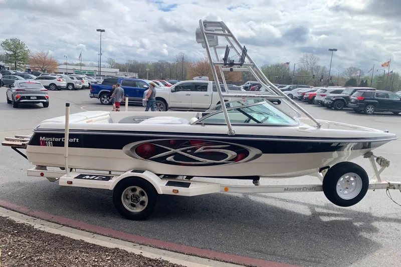 Slide: The Image of 2000 MasterCraft X5 boat on trailer in parking lot, cloudy sky background. - 5