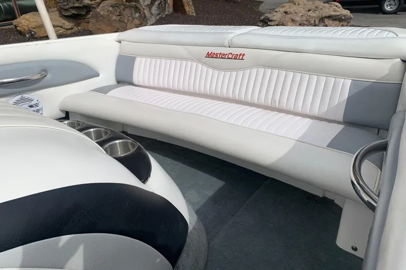 Slide: The Image of Interior of a 2000 MasterCraft X5 boat with white seating and cup holders. - 6
