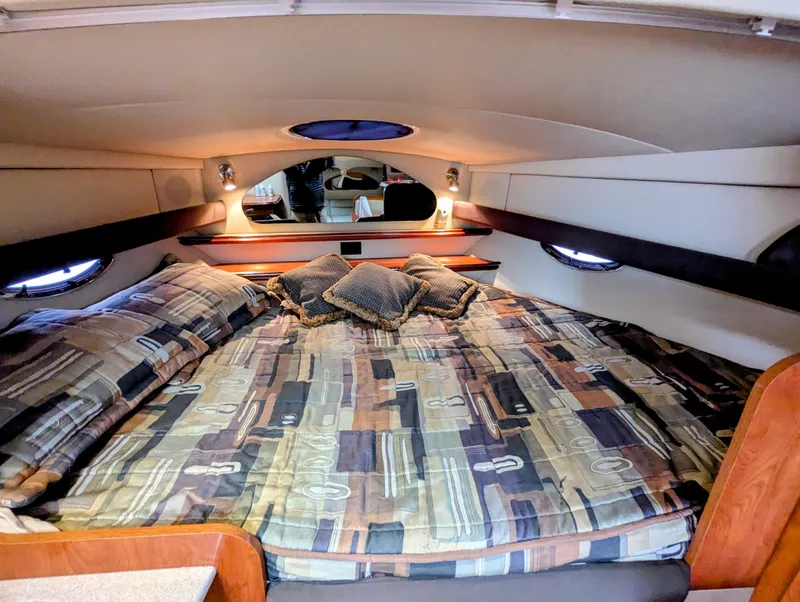 Slide: The Image of 2006 Cruisers Yachts 320 Express cabin with patterned bedding and ambient lighting. - 16