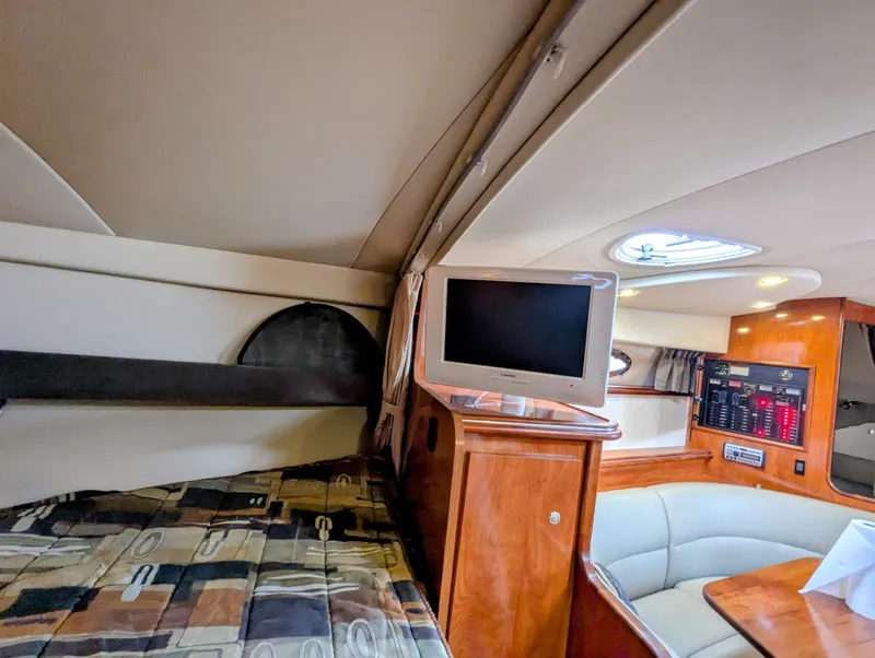 Slide: The Image of Interior of 2006 Cruisers Yachts 320 Express with TV, seating, and wood cabinetry. - 18