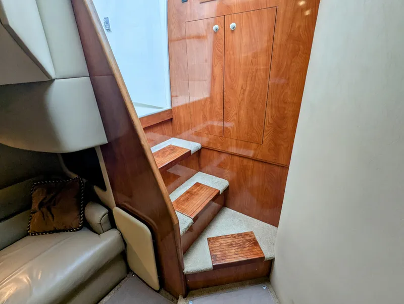 Slide: The Image of Interior of 2006 Cruisers Yachts 320 Express, featuring wooden stairs and leather seating. - 19