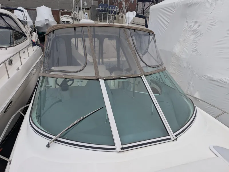 Slide: The Image of 2006 Cruisers Yachts 320 Express with covered cockpit and windshield, docked among other boats. - 26