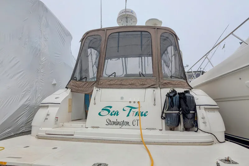 Slide: The Image of 2006 Cruisers Yachts 320 Express docked, featuring enclosed cockpit and "Sea Time" lettering. - 3