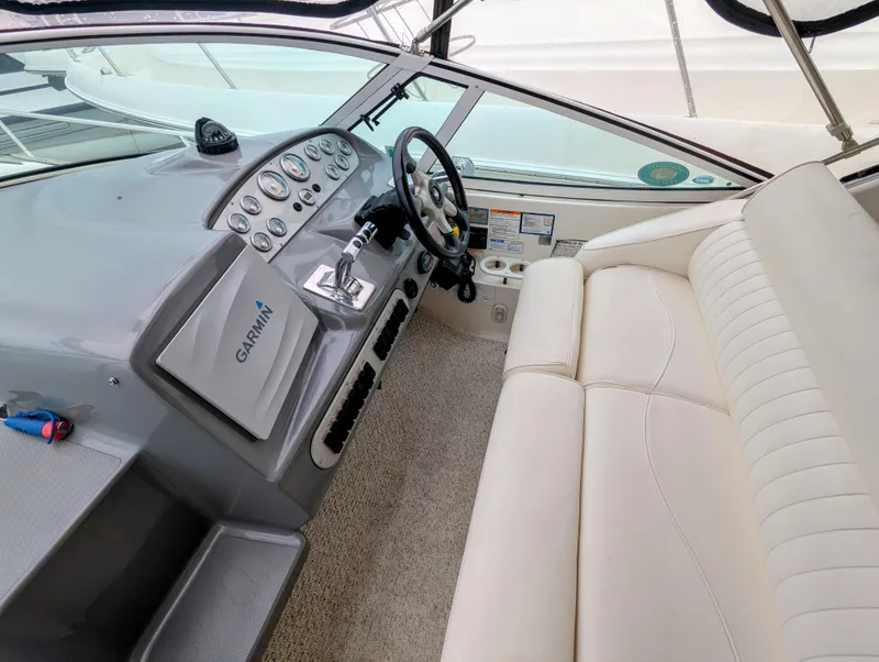 Slide: The Image of 2006 Cruisers Yachts 320 Express helm with Garmin navigation and white seating. - 6
