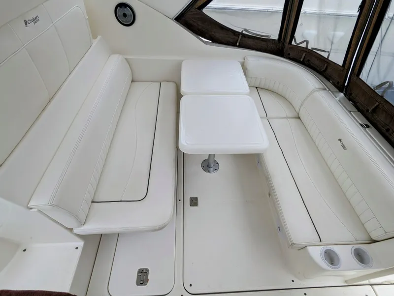 Slide: The Image of 2006 Cruisers Yachts 320 Express interior with white seating and dual tables. - 7