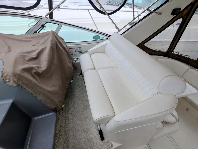 Slide: The Image of 2006 Cruisers Yachts 320 Express interior with white seating and covered dashboard. - 8